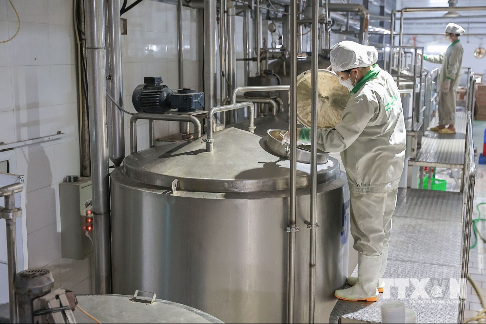 Công nhân vận hành hệ thống bồn chế biến trong dây chuyền sản xuất các sản phẩm từ sữa. (Ảnh: Lê Đông/TTXVN)